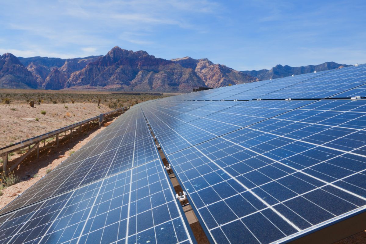 Image of solar panels in the desert with mountains in background
