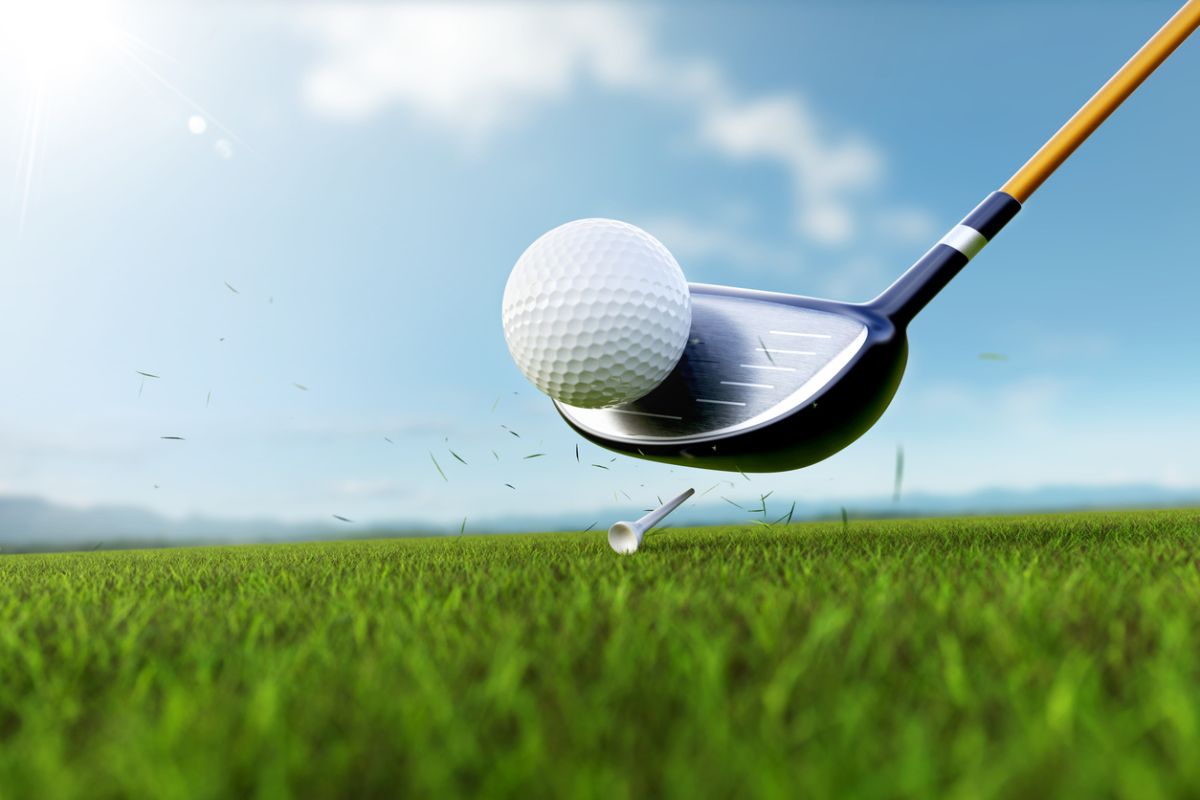 Golf club striking a ball off a tee on a sunny course representing determination and the inspiring comeback story of golfer Patrick Duke after a life-changing accident.