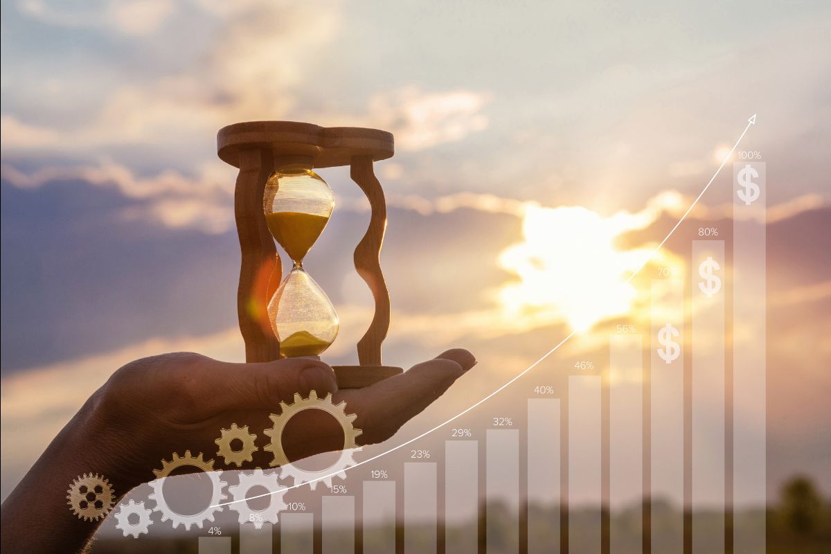Hand holding an hourglass with rising financial chart overlay, representing long-term investing and compounding returns