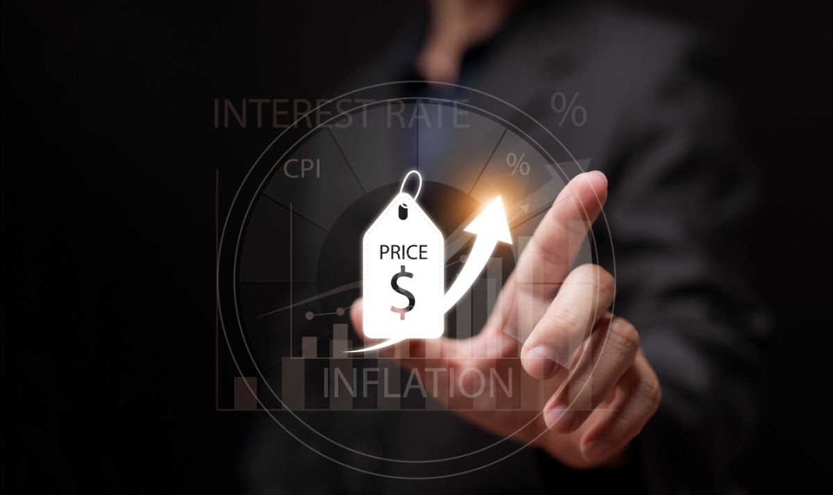 An image of a hand pointing at a rising price icon with inflation and interest rate graphics in the background.