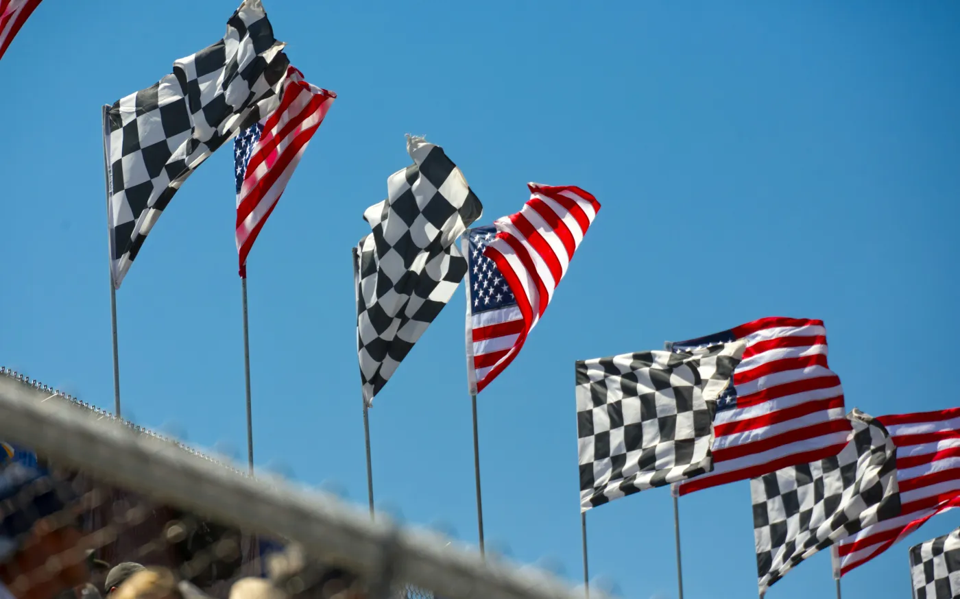 a row of checkered flags blowing in the wind by Simon Hurry courtesy of Unsplash.