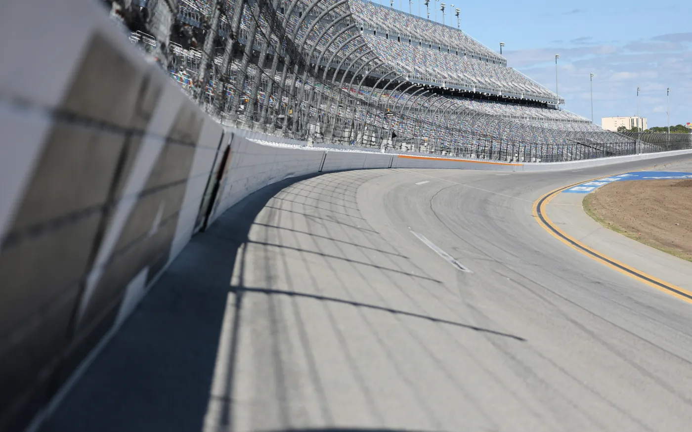 A racetrack curve and grandstands are shown. by Haomeng Yang courtesy of Unsplash.