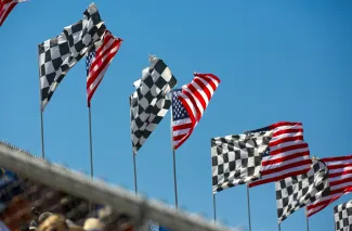 a row of checkered flags blowing in the wind by Simon Hurry courtesy of Unsplash.